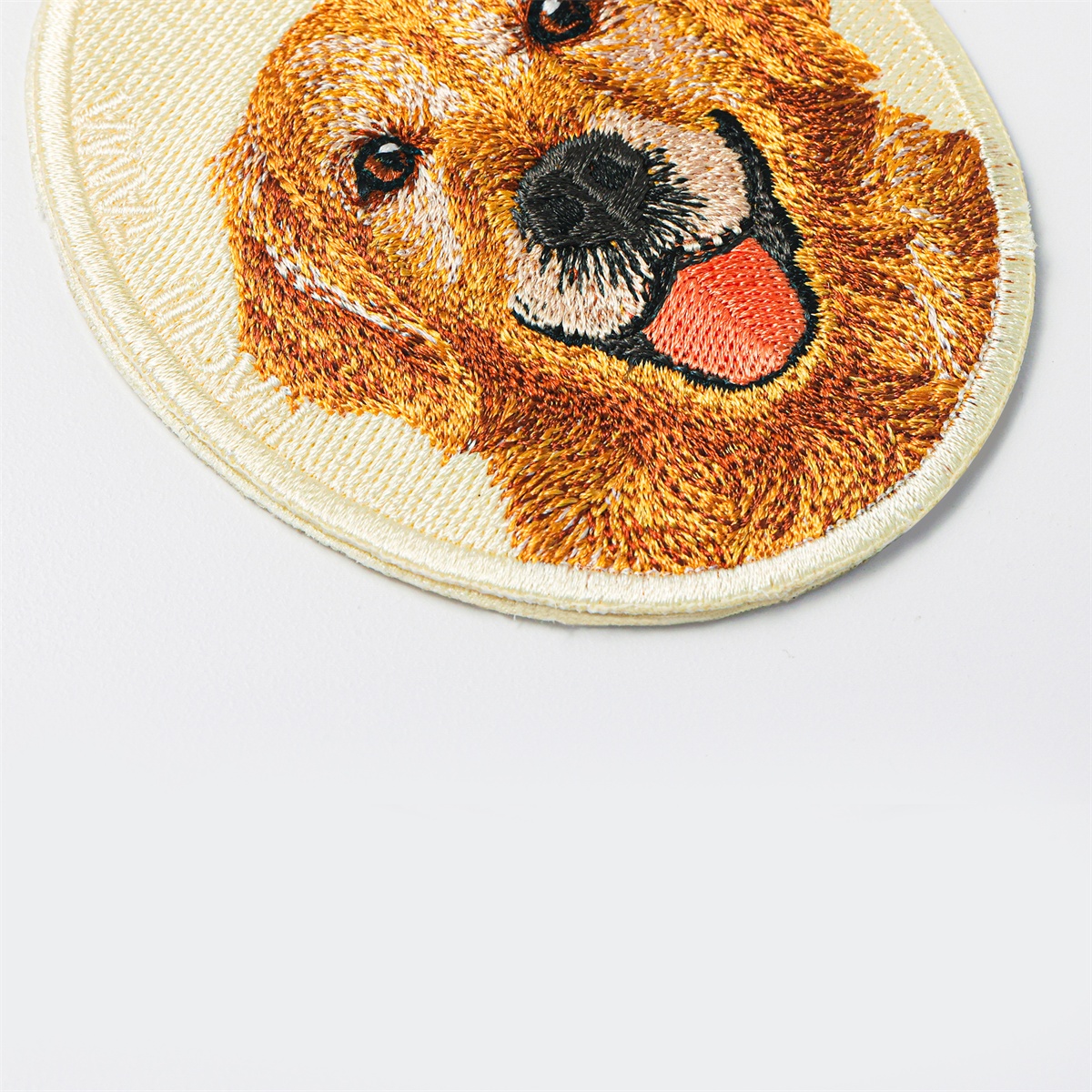Close-up of the Golden Retriever pet charm by HACHI TAMA, showing detailed embroidery