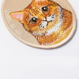 Close-up of the orange tabby cat pet charm by HACHI TAMA, showing detailed embroidery