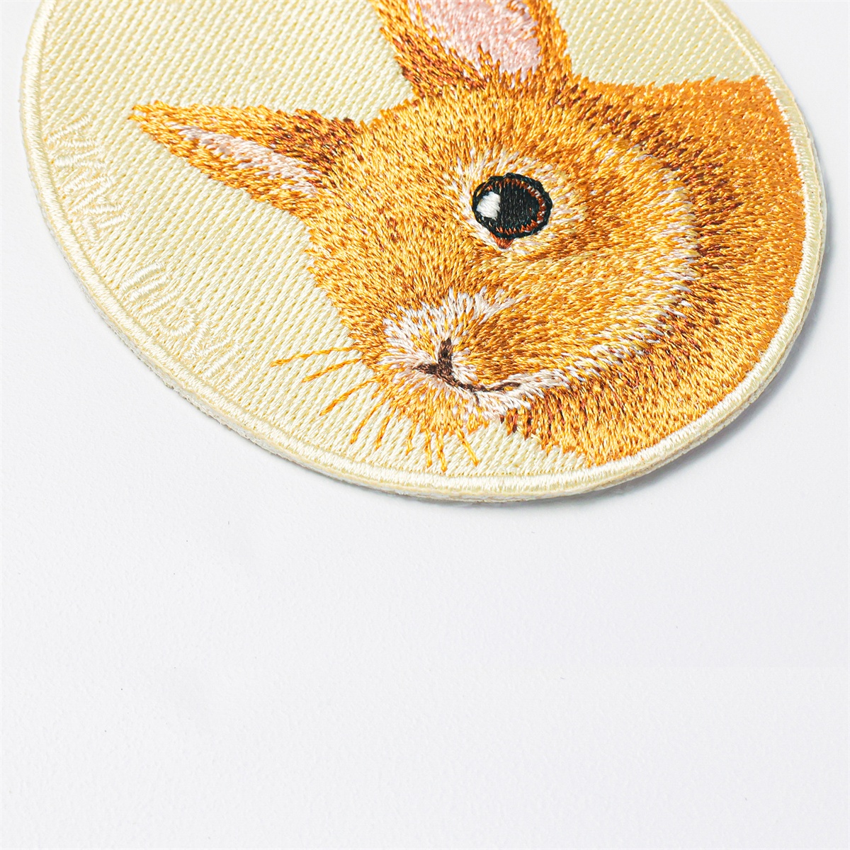 Close-up of the rabbit pet charm by HACHI TAMA, showing detailed embroidery